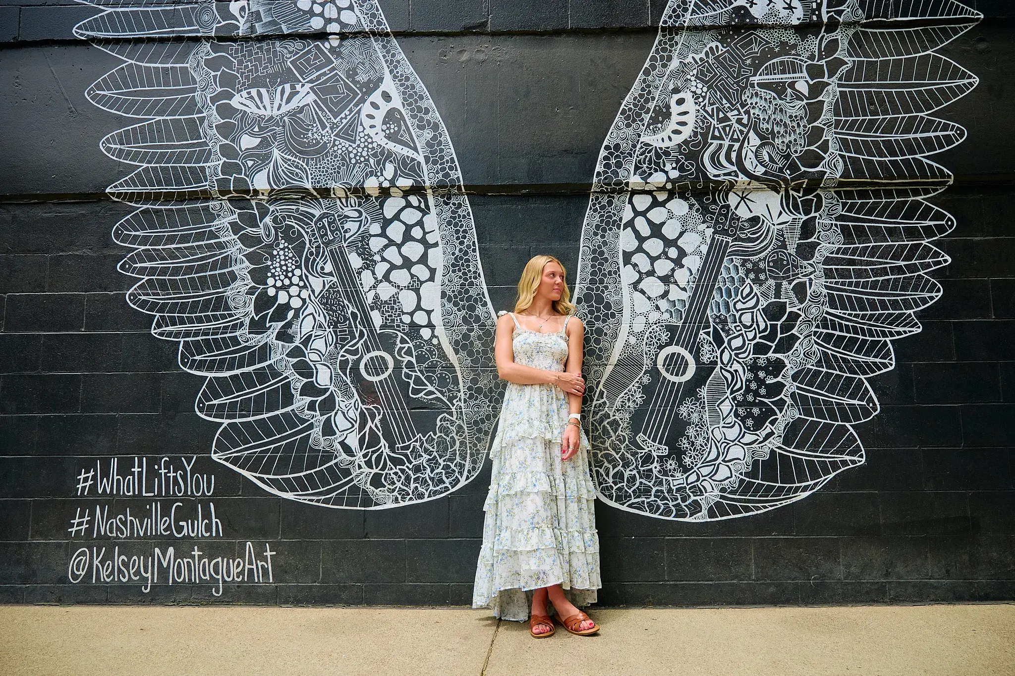Woman posing in front of Nashville wings mural during a JHR Photography mural photo tour